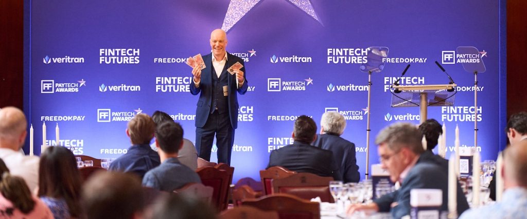 How Much does it cost to hire a magician? Magician standing on stage holding money