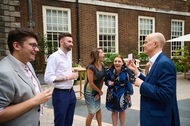 Darren Delaney performing magic at an outdoors garden party