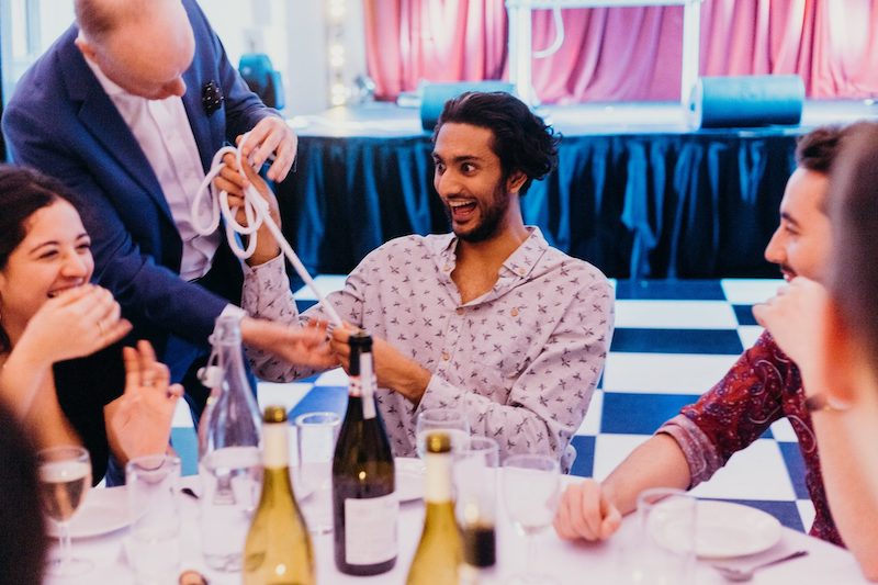 Darren Delaney performing a magic trick with rope at a dinner party