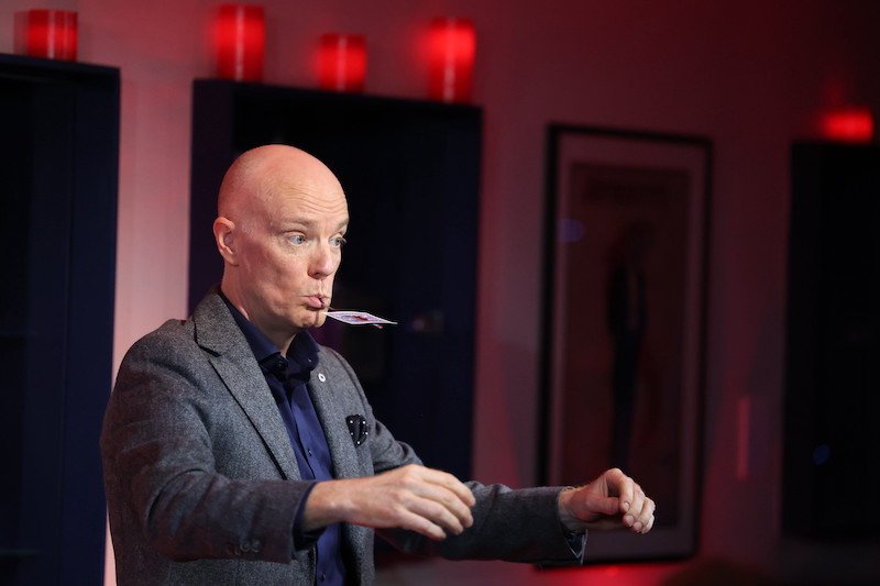 Darren Delaney performing a magic trick with a spoon at The Magic Circle