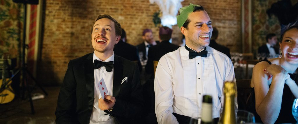 Colleagues reacting to a card trick by their Christmas party magician
