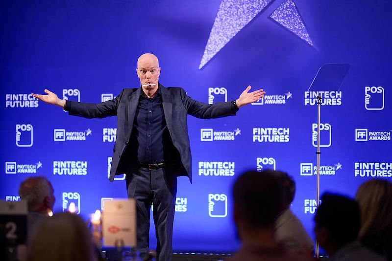 Corporate event magician Darren Delaney performing magic on stage at an awards ceremony.