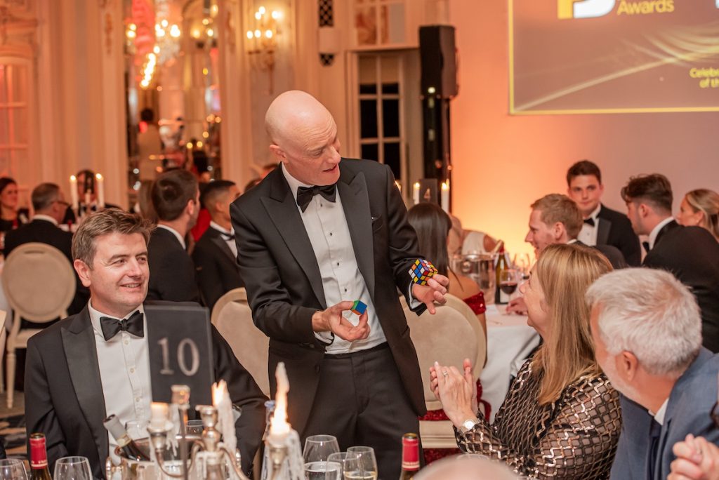 Table magician Darren Delaney performing magic with a Rubik's cube at a black-tie awards dinner