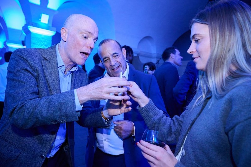 Darren Delaney performing a magic trick with a pen for guests at a corporate event