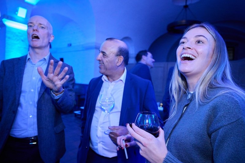 people reacting to Darren Delaney's close-up magic at an event in The Crypt at St Paul's