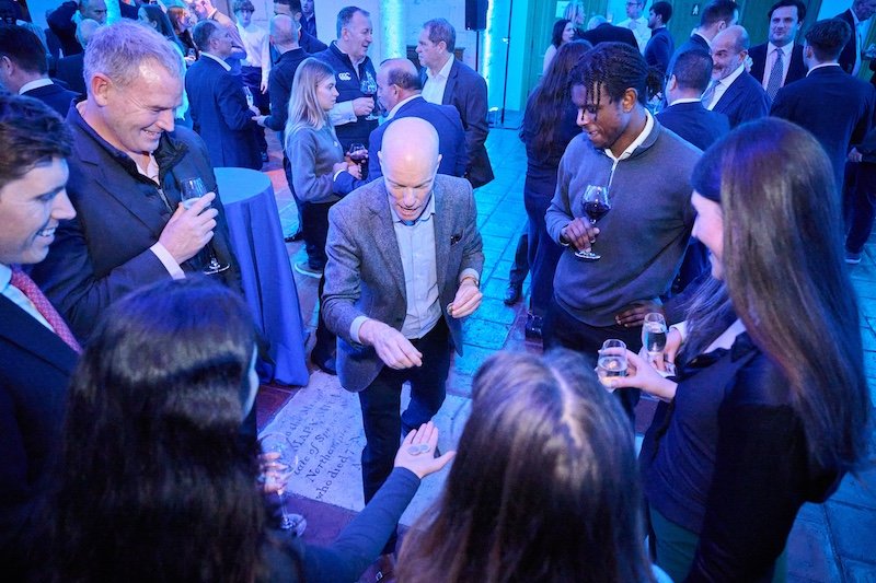 Darren Delaney performing magic with coins for a group of people at a corporate event