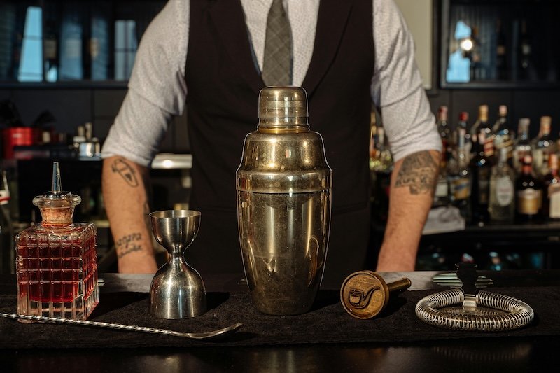 A bartender standing at a cocktail bar. Hiring a cocktail bar is a great idea for a 40th birthday party