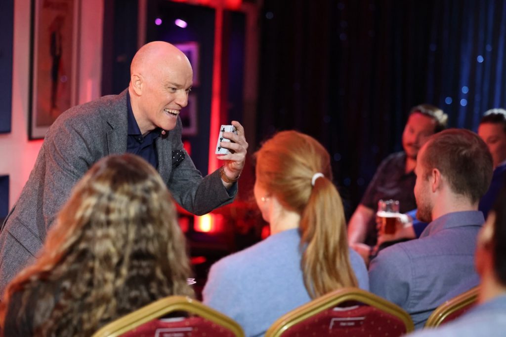 A magician performing card tricks at a private party.