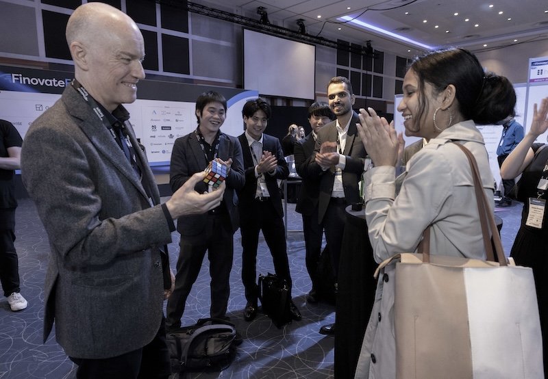 Darren Delaney performing magic with a Rubik's cube for a small group at Finovate Europe 2026