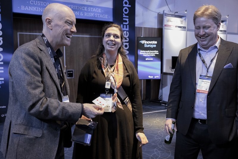 Darren Delaney performing magic with cards for a two people at Finovate Europe 2026