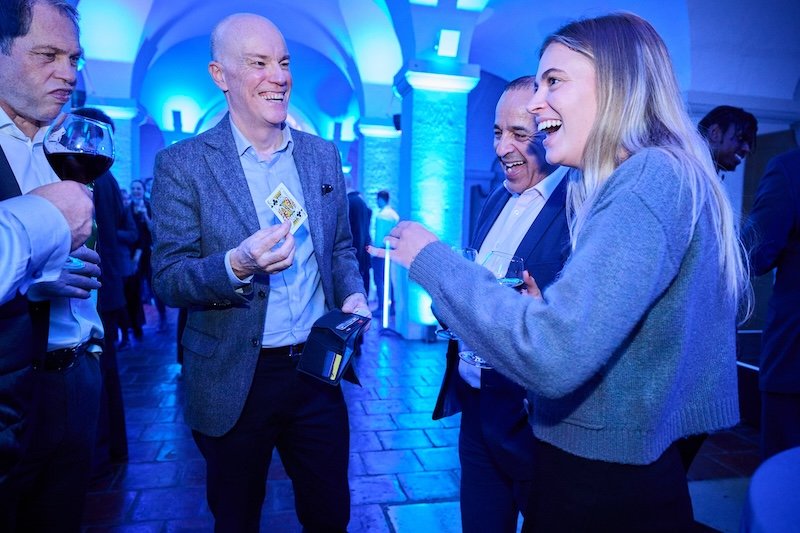 corporate magician Darren Delaney performing close-up magic at a business networking drinks event.